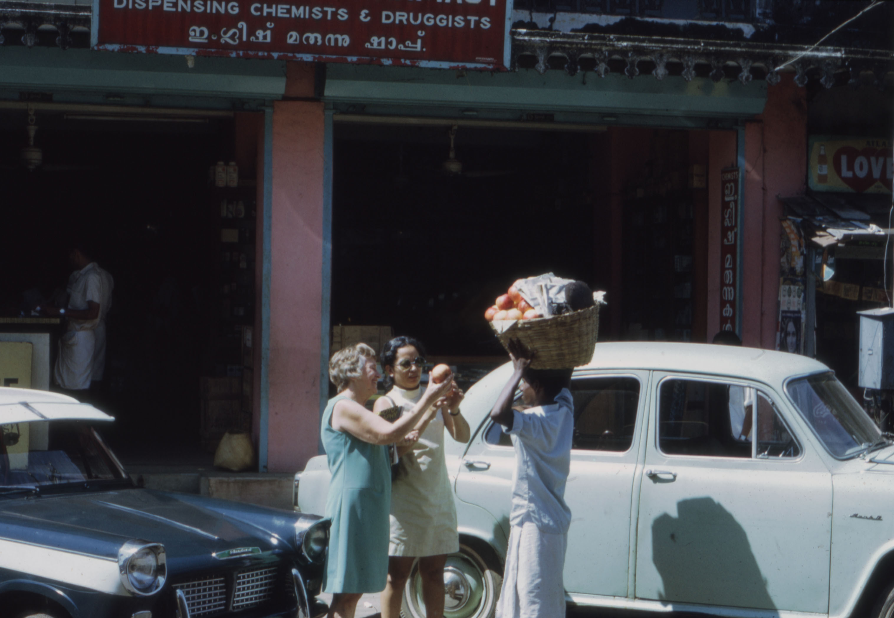 Two ladies engage with merchant infront of chemist